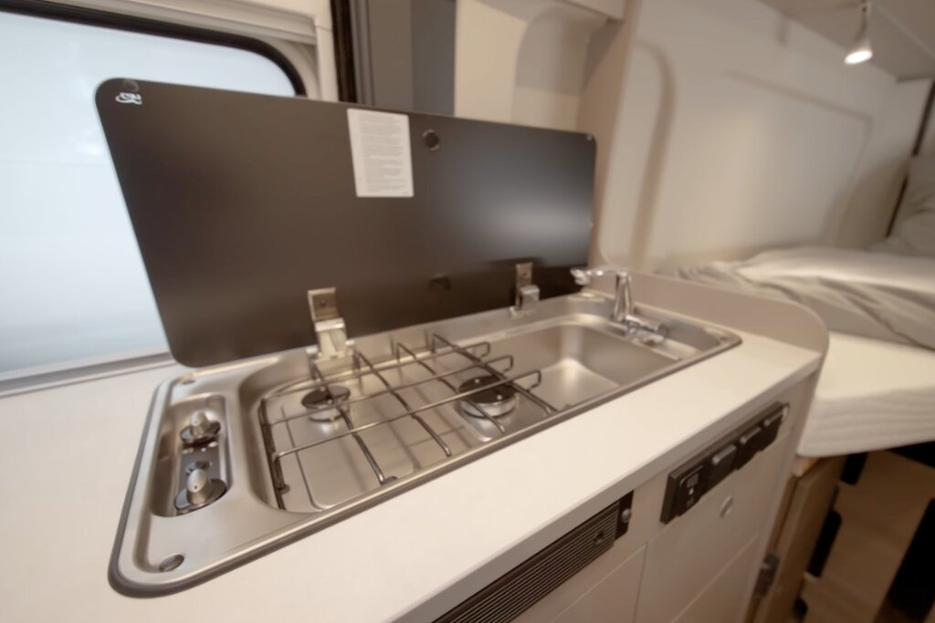 Küchenzeile im Carado Wohnmobil mit zweiflammigem Gasherd, Spüle und Glasabdeckung