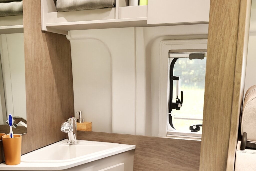 Bad im Carado Wohnmobil mit Waschbecken, Spiegel, Fenster und Oberschrank