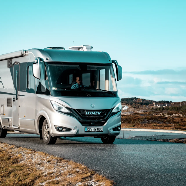 Fahrende HYMER B-Klasse MasterLine I in skandinavischer Küstenlandschaft mit Meer und blauem Himmel