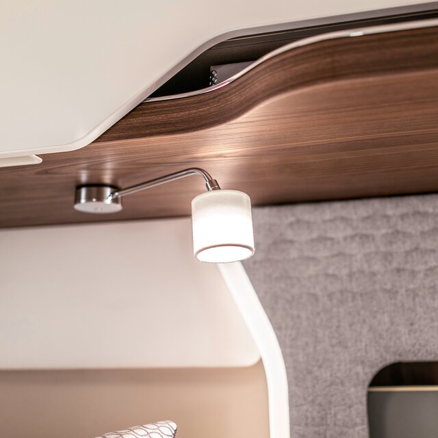 Leselampe mit silbernem Arm und weißem Schirm im Bettbereich beim Reisemobil HYMER B-Klasse MasterLine I
