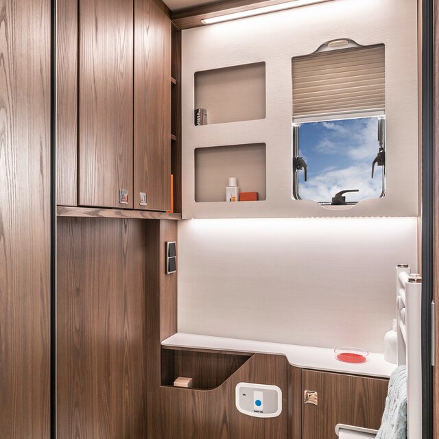 Tageslichtbad mit Ablagefläche, Waschbecken; Handtuchhalter, Spiegel, Kleiderhaken und Toilette im HYMER B-ML I 880
