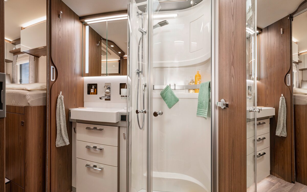 Salonbad im HYMER B-ML I 880: Spiegelschrank, Schubladen unterm Waschbecken, separate Dusche mit Echtglastüren, Badutensilien