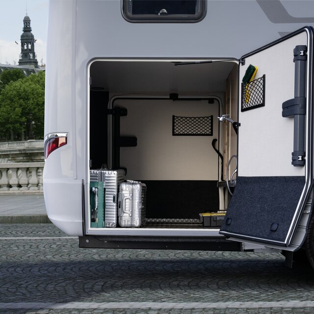 In Fahrtrichtung rechts geöffnete Tür der mit zwei silbernen Koffern beladenen Heckgarage des HYMER B MasterLine