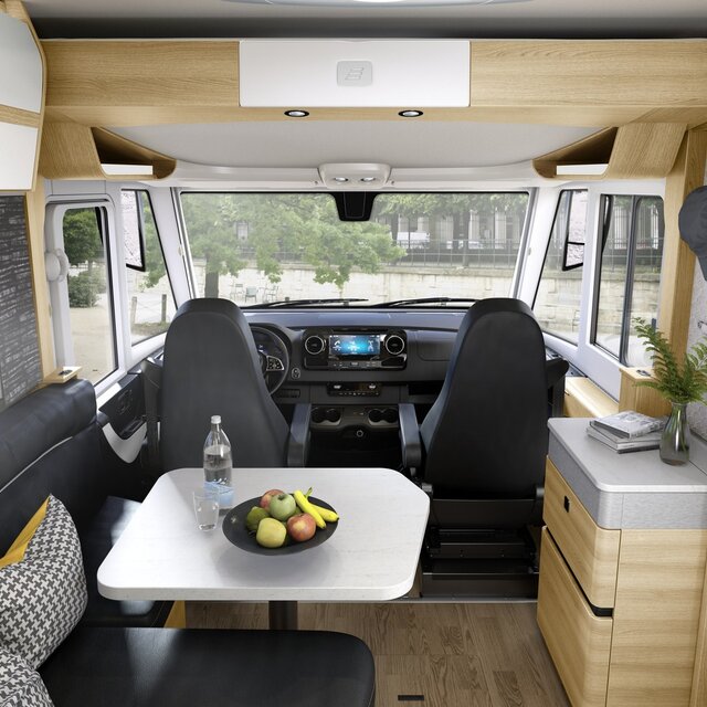 Dekorierter Wohnraum im HYMER-Reisemobil B-Klasse MasterLine mit schwarzer Sitzgruppe und hellen Möbeln