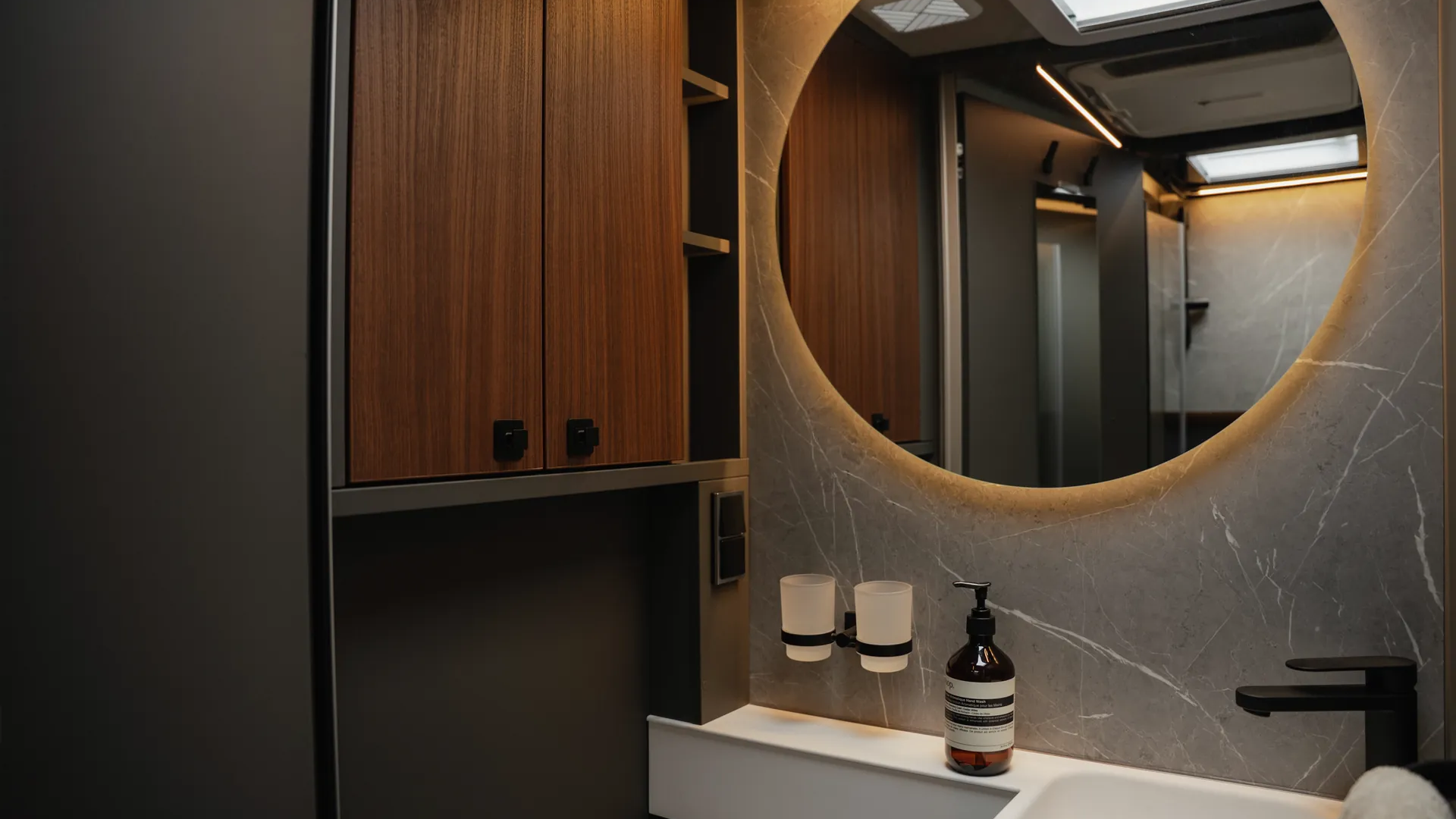 Der beleuchtete Rundspiegel und die indirekte Ambientebeleuchtung schaffen eine Atmosphäre, die Wertigkeit, Ruhe und modernes Design harmonisch vereint.