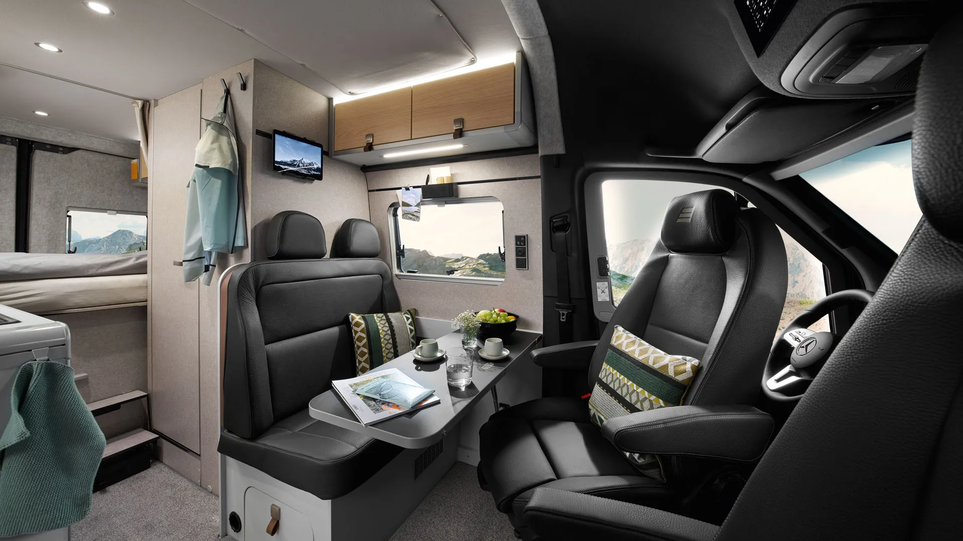The living area of the HYMER Grand Canyon S in the Pearl Grey style world photographed from the passenger seat.