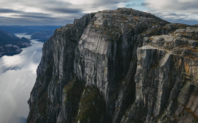 Utsikt over et stort fjell med utsiktsplattform, fjord til venstre i bakgrunnen