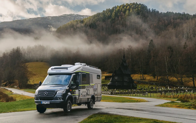 Utsikt over HYMER ML-T CrossOver, Borgund stavkirke er synlig i bakgrunnen, skoger med høye trær bak kirken