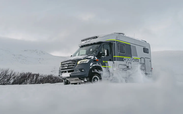 Diagonal utsikt fra høyre front på HYMER ML-T 570 CrossOver, kjører gjennom et vinterlig, snødekt landskap