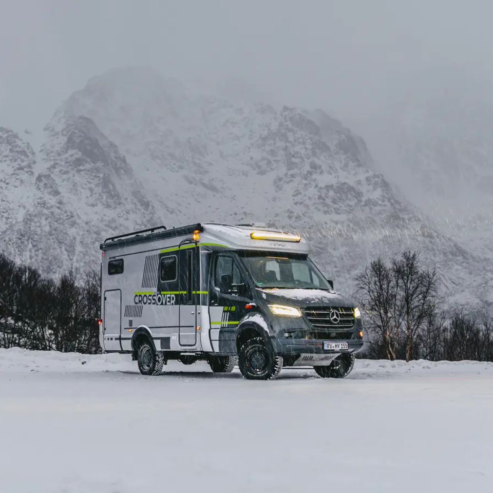 Sideutsikt av HYMER ML-T 570 CrossOver, høye snødekte fjell i bakgrunnen